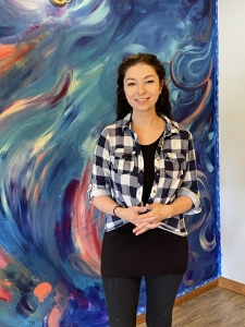 Elizabeth Londen standing in front of her beautiful swirly painted mural