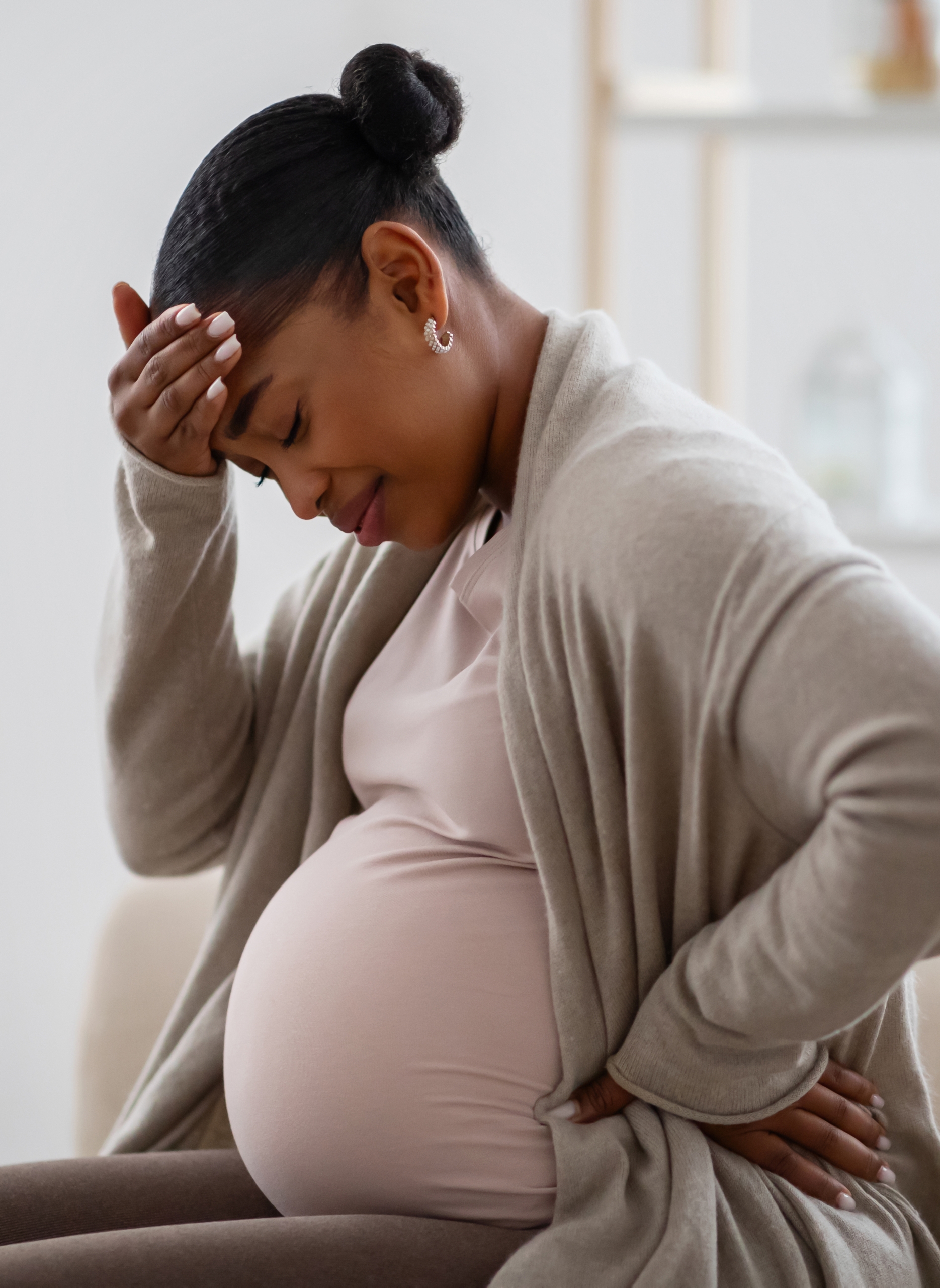 African american expecting woman suffering from headache at home